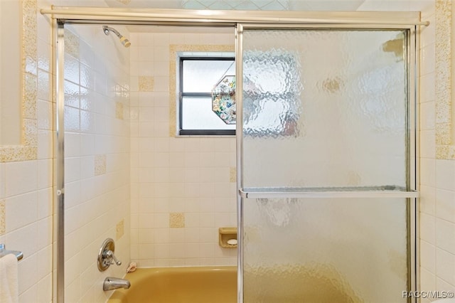 bathroom with shower / bath combination with glass door