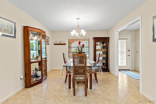 dining space with plenty of natural light, light tile patterned floors, a notable chandelier, and a textured ceiling