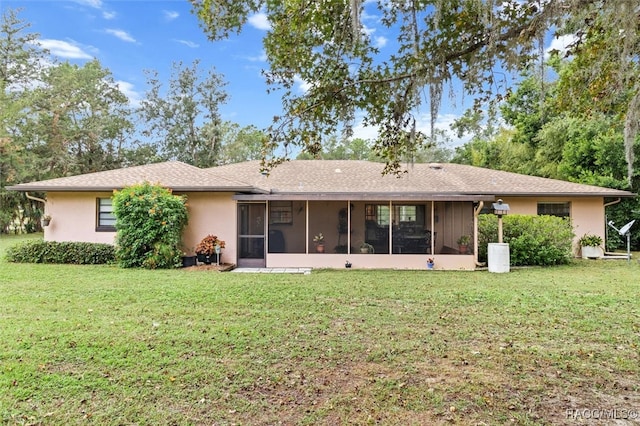 rear view of property with a yard and a sunroom