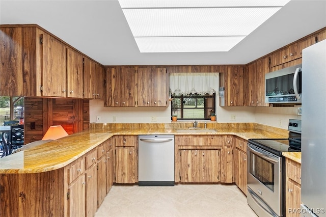 kitchen with sink, a wealth of natural light, stainless steel appliances, and kitchen peninsula