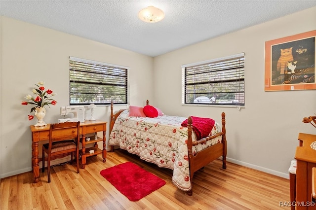 bedroom featuring light hardwood / wood-style flooring and a textured ceiling