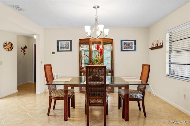 dining area featuring light tile patterned flooring and an inviting chandelier