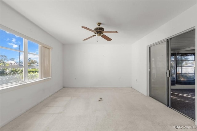 unfurnished room with light colored carpet and ceiling fan