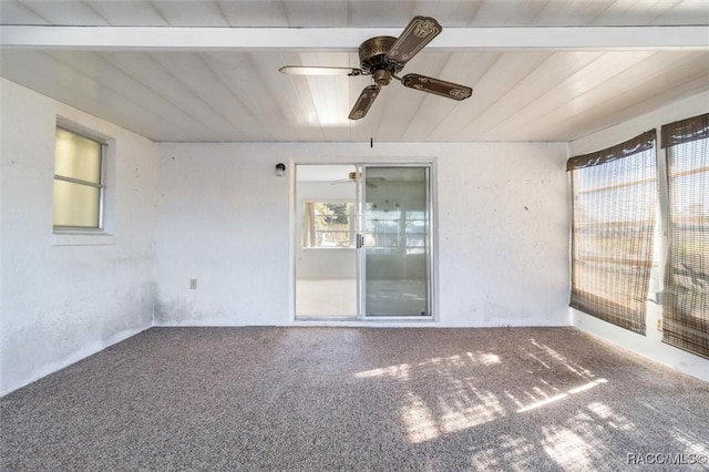 unfurnished room featuring beam ceiling and carpet