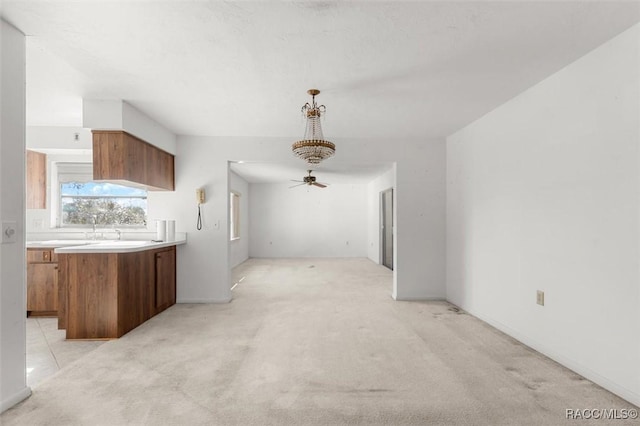 interior space featuring light carpet, ceiling fan, and pendant lighting