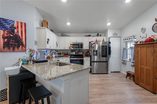 10541 S Drew Bryant Cir, Floral City, FL 34436 - kitchen with a sink, stainless steel appliances, a peninsula, white cabinetry, and light stone countertops
