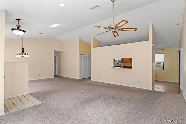 unfurnished living room featuring lofted ceiling, ceiling fan with notable chandelier, and light colored carpet