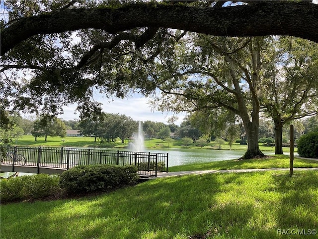 view of community featuring a water view and a lawn