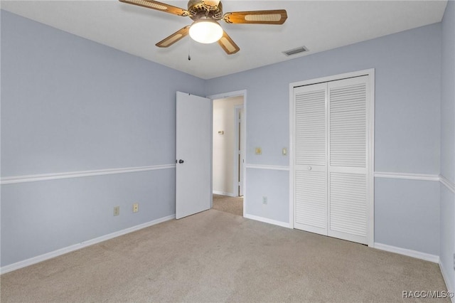 unfurnished bedroom featuring light carpet, ceiling fan, and a closet