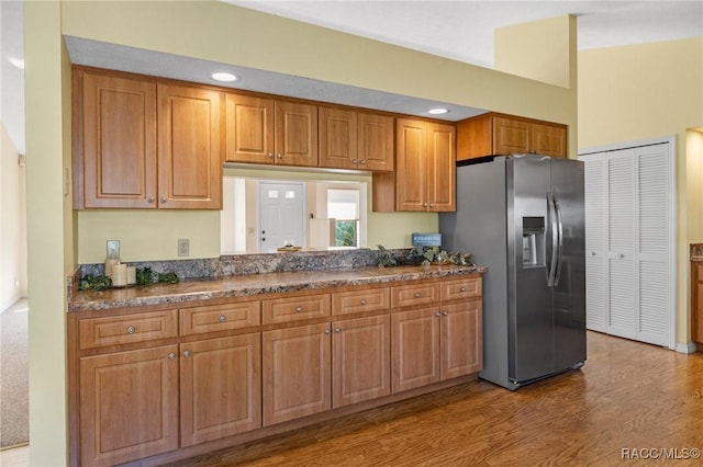 kitchen featuring stainless steel refrigerator with ice dispenser and light wood-type flooring