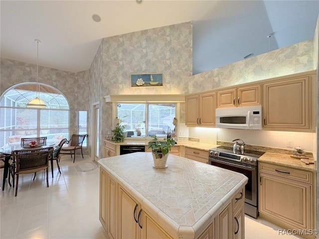 kitchen featuring high vaulted ceiling, dishwasher, stainless steel electric range, a kitchen island, and pendant lighting