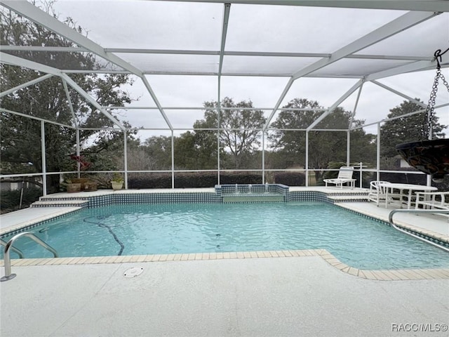 view of swimming pool featuring a lanai and a patio area