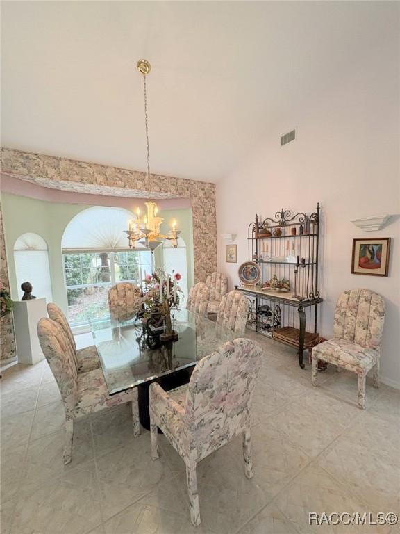 dining space featuring high vaulted ceiling and an inviting chandelier