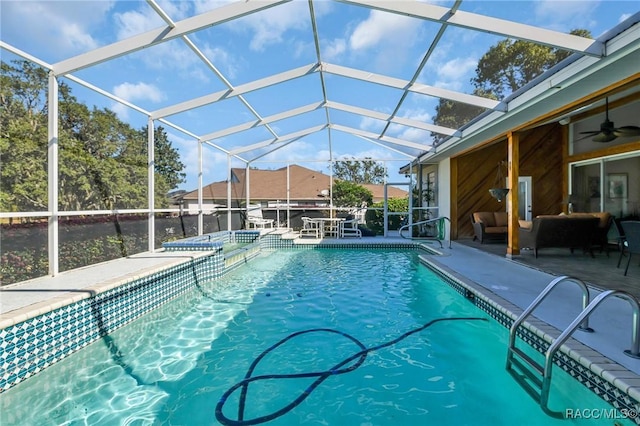 view of swimming pool featuring glass enclosure, a patio area, an outdoor living space, and ceiling fan