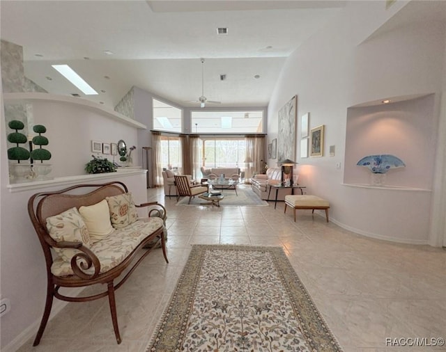 living room featuring ceiling fan, light tile patterned floors, and a towering ceiling