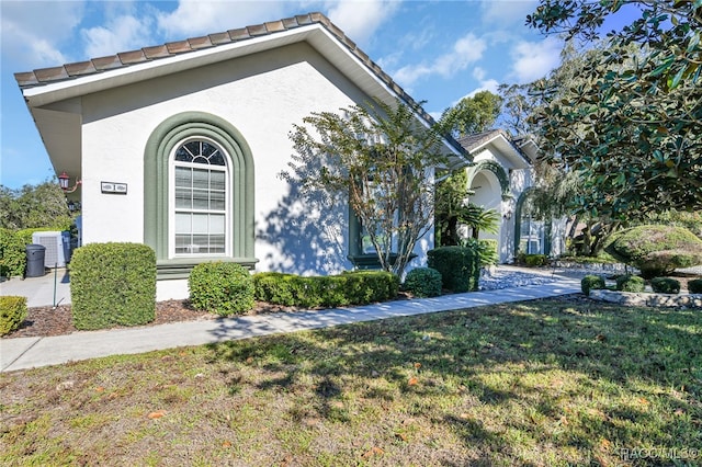 view of front of home with a front lawn and central AC unit