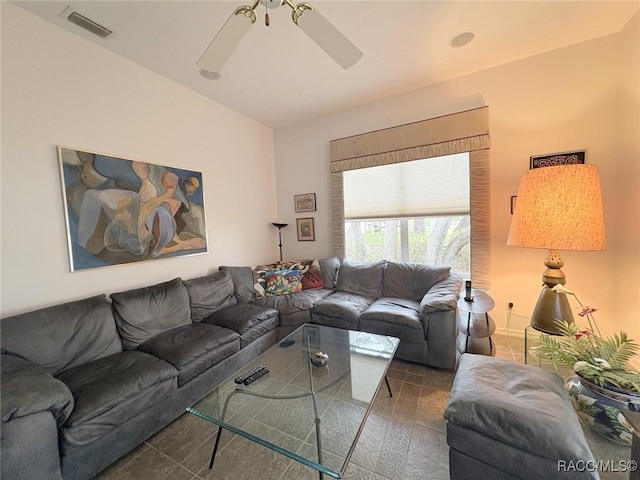 living room with ceiling fan and dark tile patterned floors