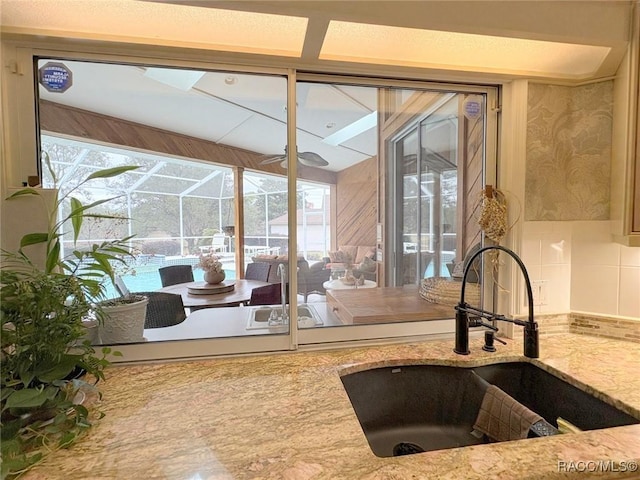 kitchen featuring sink and light stone counters