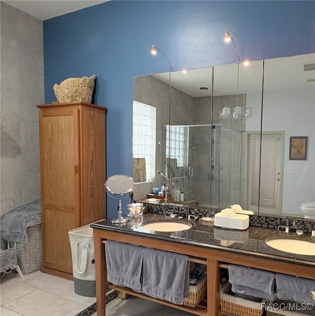 bathroom featuring a shower with shower door, vanity, and tile patterned flooring