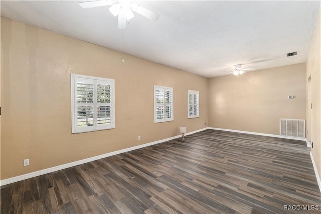 unfurnished room featuring a ceiling fan, wood finished floors, visible vents, and baseboards