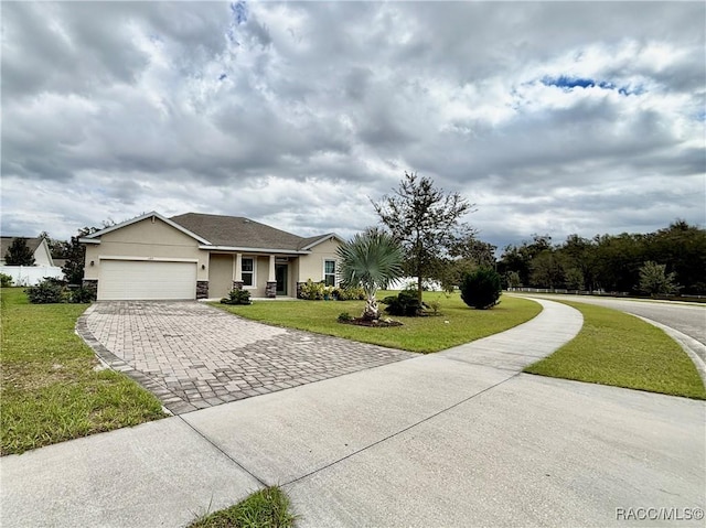 single story home with a front lawn, decorative driveway, an attached garage, and stucco siding