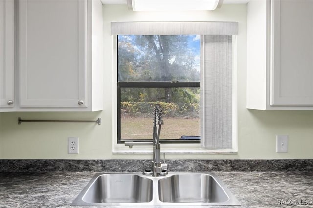 kitchen featuring white cabinets and sink