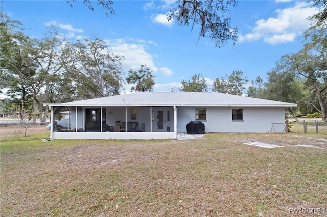 back of property featuring a yard and a sunroom