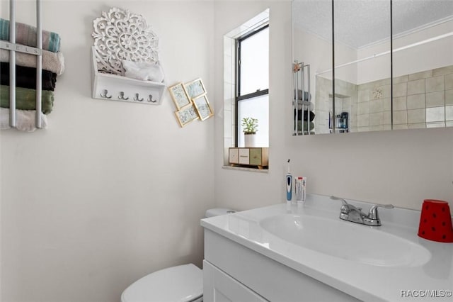 bathroom featuring vanity, a textured ceiling, toilet, and crown molding