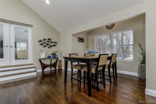 dining room with a textured ceiling, vaulted ceiling, dark wood-type flooring, and french doors