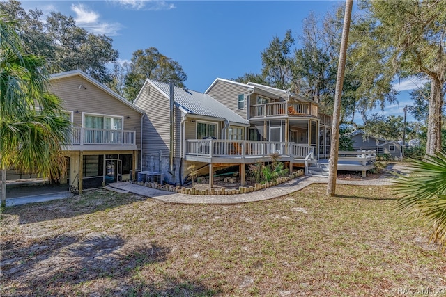 rear view of property with a balcony and a deck