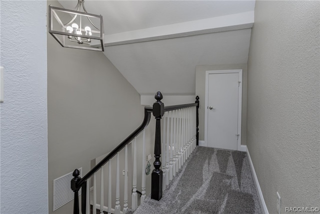 stairway featuring carpet and a notable chandelier