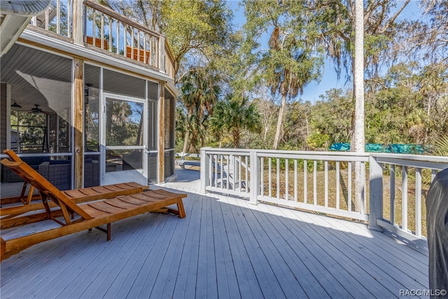 wooden terrace featuring a sunroom and ceiling fan