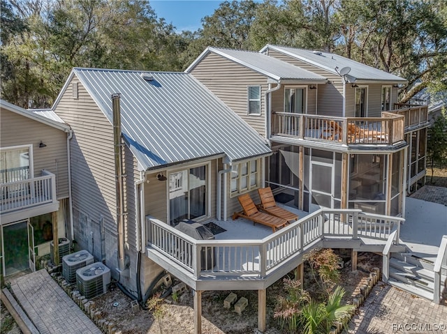 back of property with central air condition unit, a wooden deck, and a sunroom