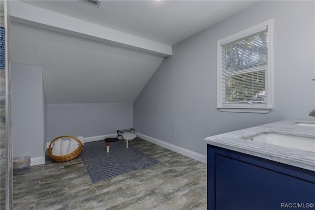 clothes washing area with a textured ceiling and sink