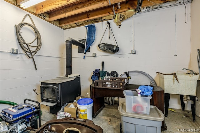 basement featuring a wood stove and sink