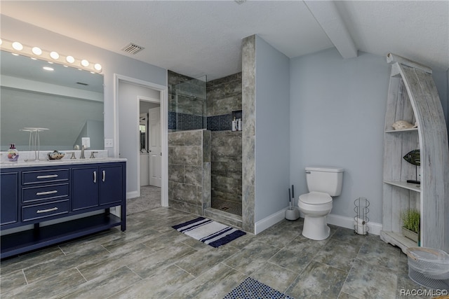 bathroom featuring a tile shower, vanity, a textured ceiling, vaulted ceiling, and toilet