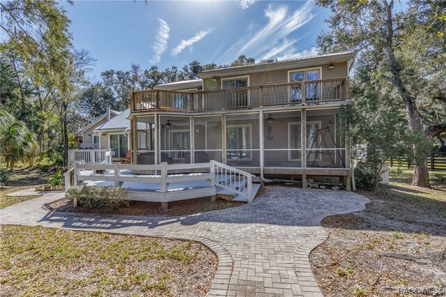 view of front of house with a sunroom, a balcony, and a deck