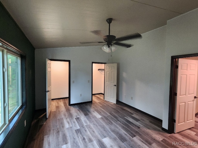 unfurnished bedroom featuring hardwood / wood-style flooring, ceiling fan, lofted ceiling, and multiple windows