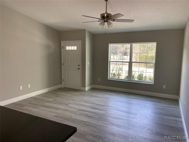 entryway with ceiling fan, hardwood / wood-style floors, and a textured ceiling