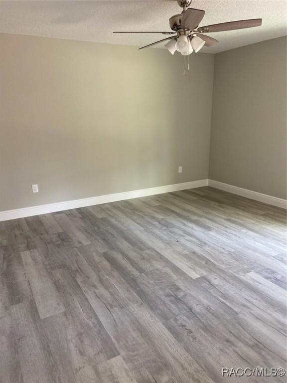 spare room featuring ceiling fan, hardwood / wood-style floors, and a textured ceiling