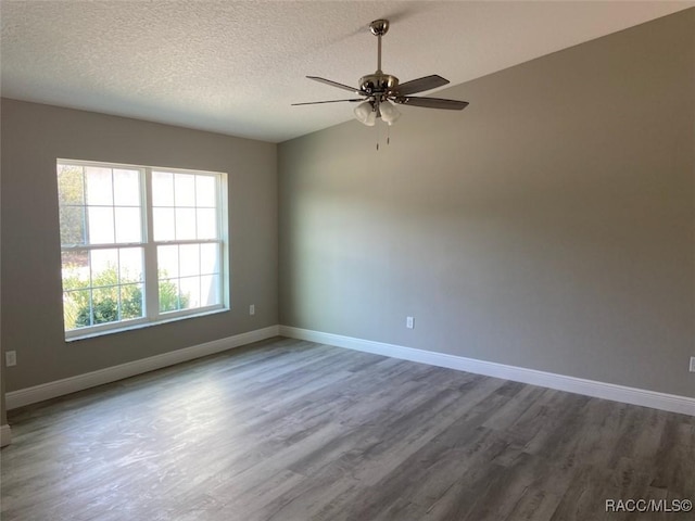 empty room with wood-type flooring, ceiling fan, and a textured ceiling