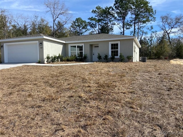 ranch-style house featuring a garage and central AC unit