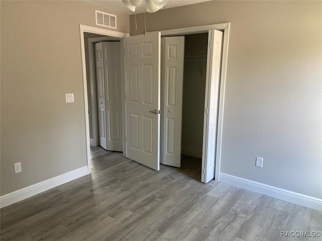 unfurnished bedroom featuring hardwood / wood-style floors and a closet