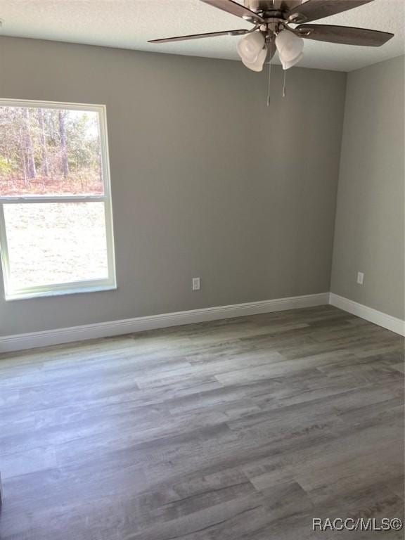 empty room with ceiling fan, hardwood / wood-style floors, and a textured ceiling