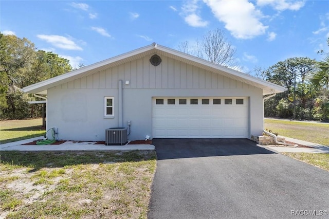 view of side of home with central AC unit and a garage