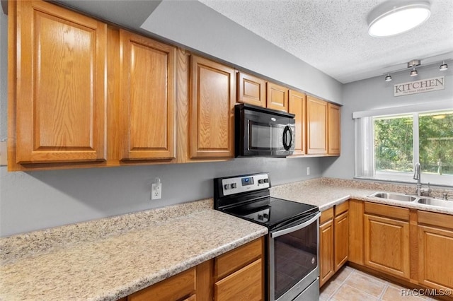 kitchen featuring light countertops, stainless steel electric stove, black microwave, and a sink