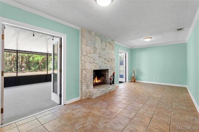 unfurnished living room with visible vents, plenty of natural light, a fireplace, and ornamental molding