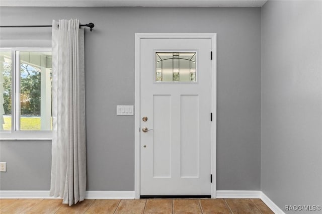 tiled entryway featuring baseboards