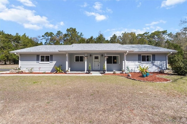 ranch-style house featuring covered porch and a front yard