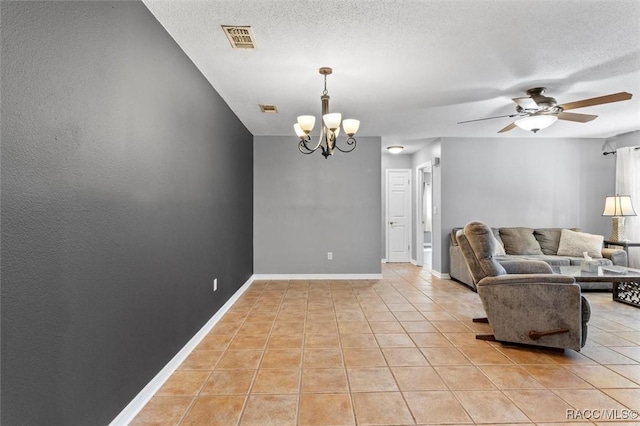 living area with baseboards, visible vents, light tile patterned flooring, a textured ceiling, and ceiling fan with notable chandelier